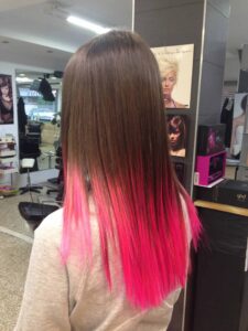 Chica con pelo largo y liso con las puntas de color rosa fluor de Peluqueros de Moda