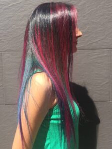 Mujer con reflejos granates sobre melena oscura de Peluqueros de Moda