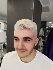 Chico con corte de pelo moderno y decoloración rubio platino de Peluqueros de Moda
